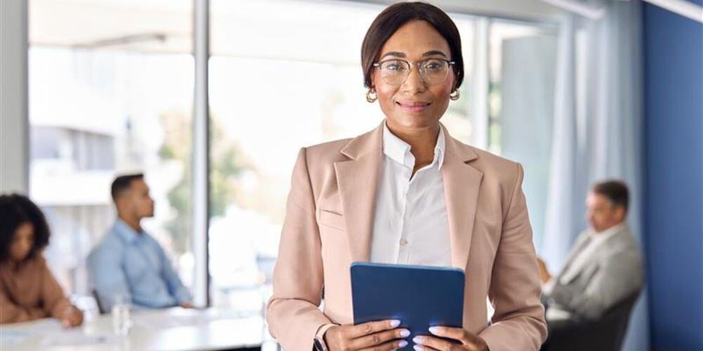 A confident business professional holding a tablet, representing leadership and decision-making in understanding vCIO services cost.