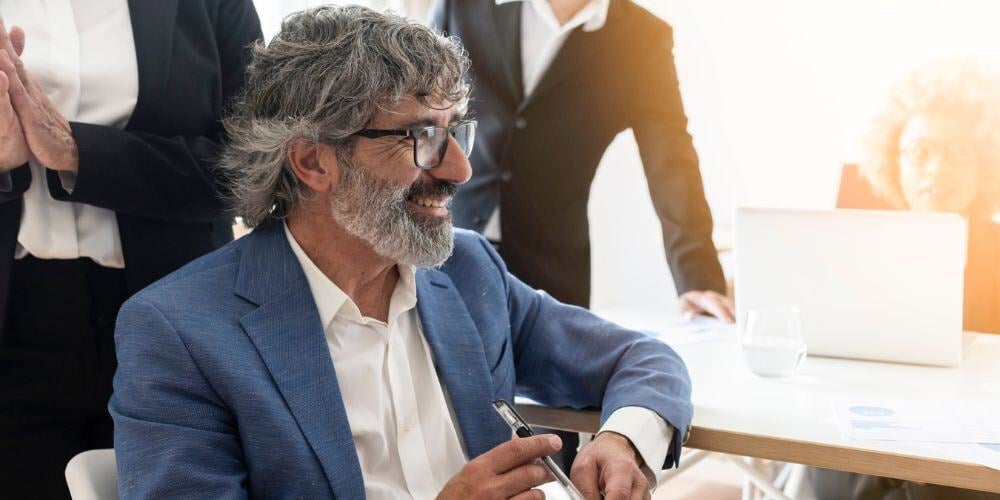 A smiling business leader in a meeting, representing discussions around what a vCIO is and how it will help organizations grow
