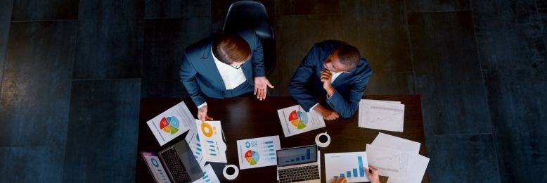 Aerial view of business professionals at a strategic meeting focusing on FINRA compliance