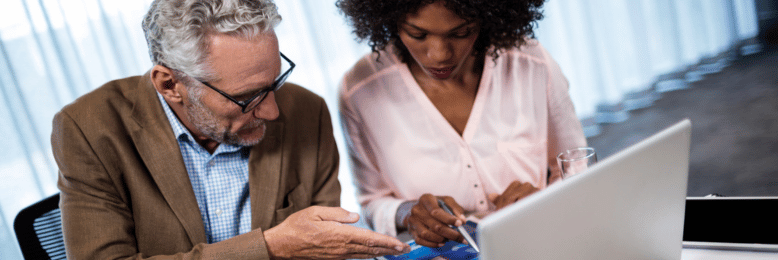Business consultants analyzing co-managed IT cost charts on a laptop