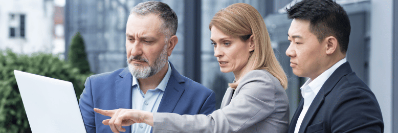 Business team outdoors comparing IT service options on a laptop screen