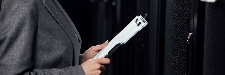 Businesswoman in data center reviewing SOC 1 compliance documentation