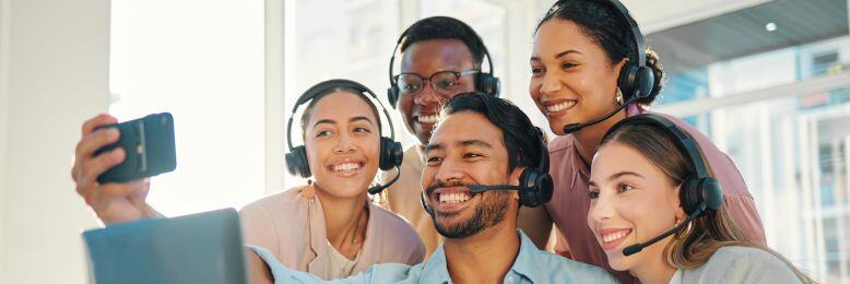 Customer support team using 3CX VoIP, capturing a group selfie to celebrate service success