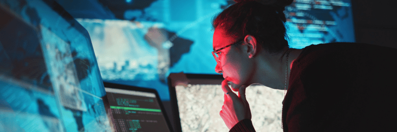 Cybersecurity analyst intensely monitoring data for threat isolation on screens