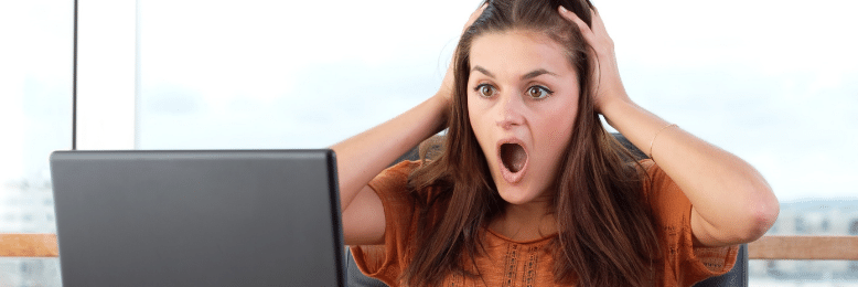 hocked woman looking at computer screen, possibly facing data backup failure