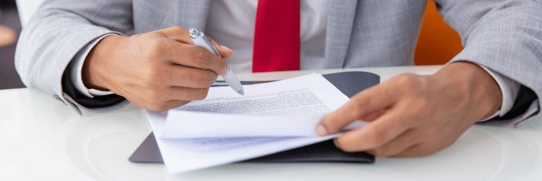 Executive signing a document related to SEC cybersecurity disclosure compliance