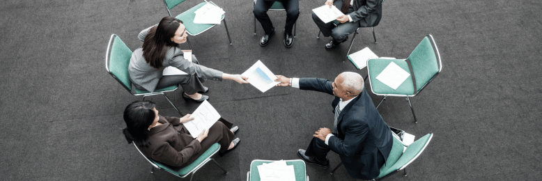 Executives seated in a circle reviewing managed IT provider proposals