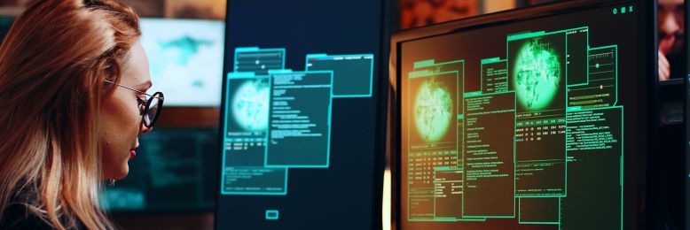 Female cybersecurity professional conducting a vulnerability scan on multiple monitors