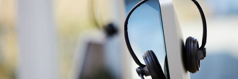 Headset on the monitor stand in an office, representing 3CX VoIP services