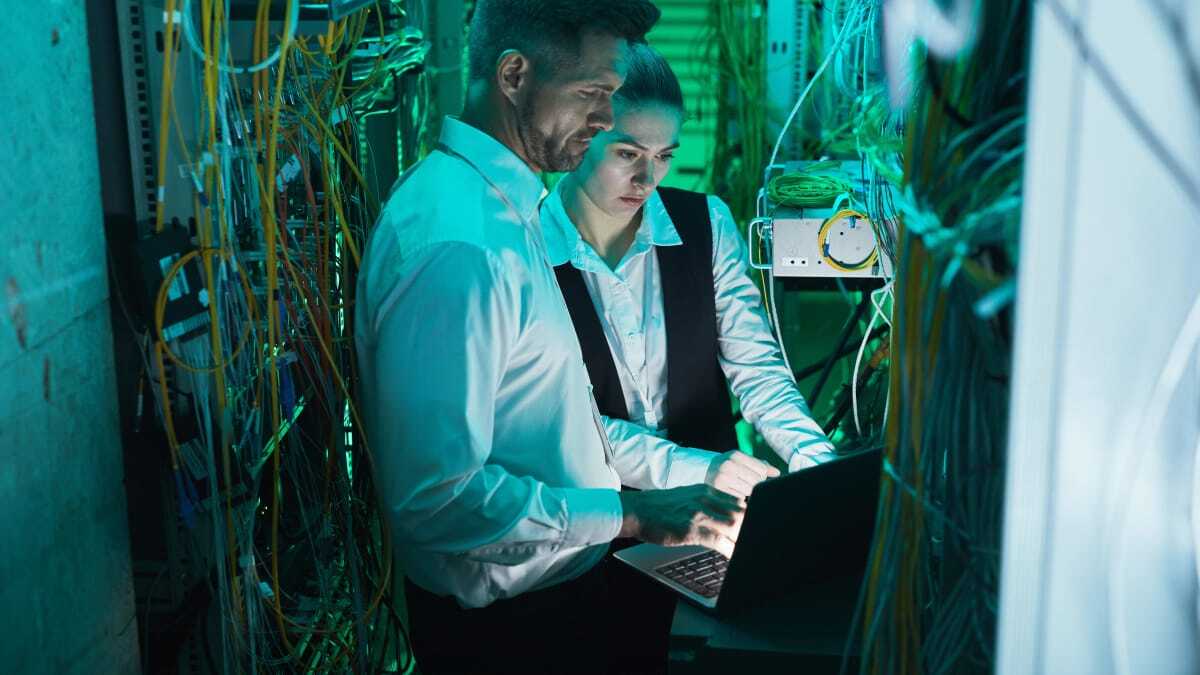 Network engineers configuring connections in a server rack