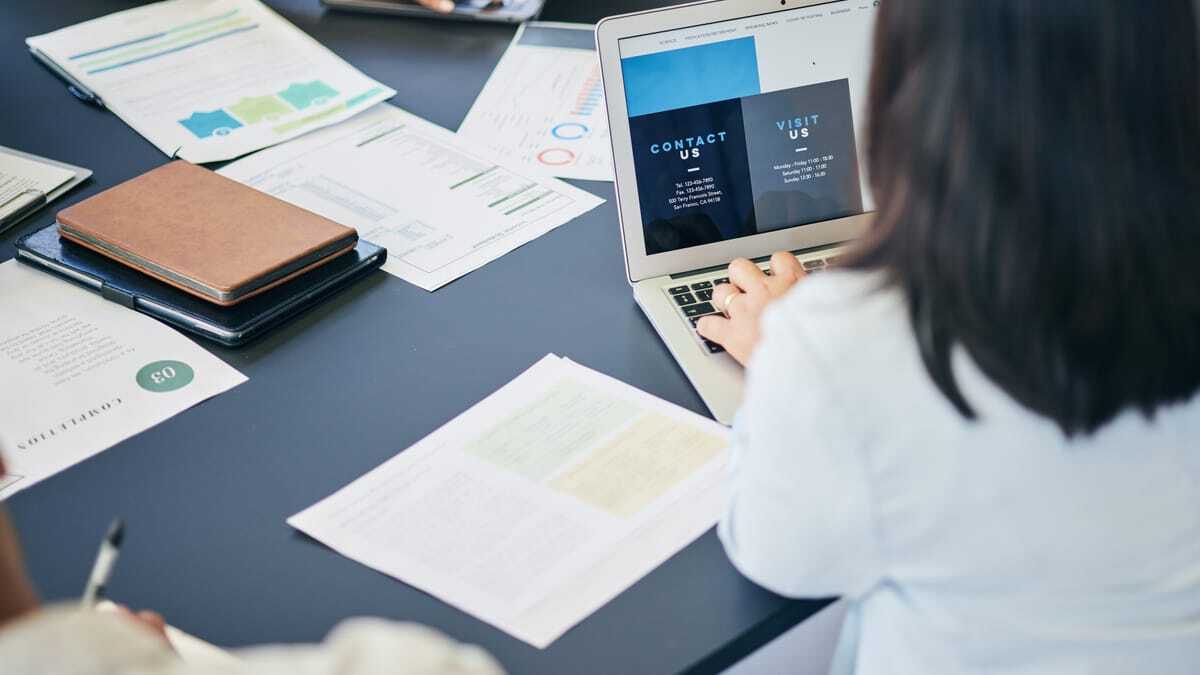 Team meeting around a table with laptops and documents