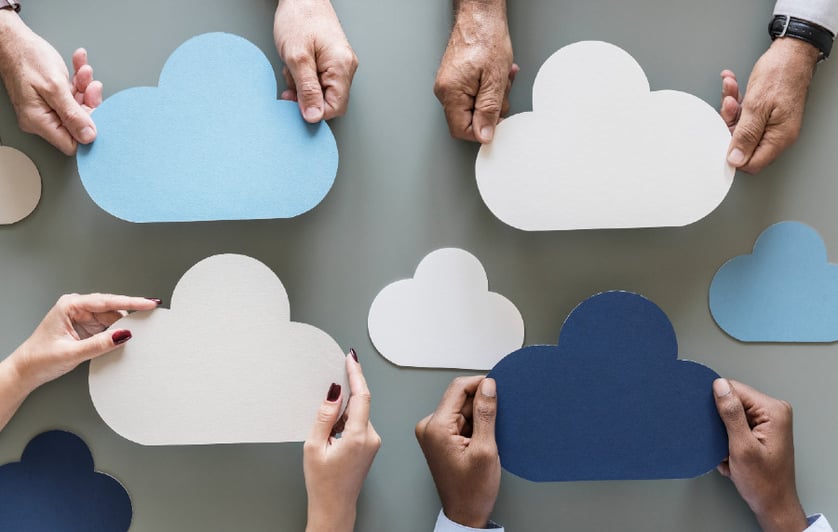 Multiple people holding out cloud shaped papers