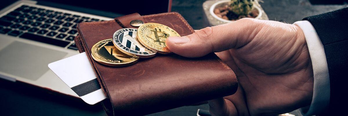 A hand holding a wallet making payment using bitcoin