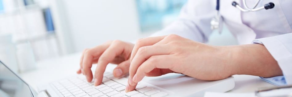A healthcare personnel using a laptop