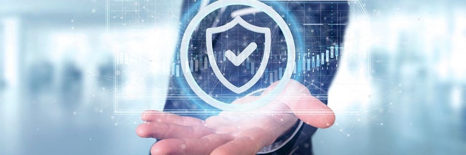 A hand holding a hologram of a shield with a checkmark inside denoting protection from Cyber Attacks