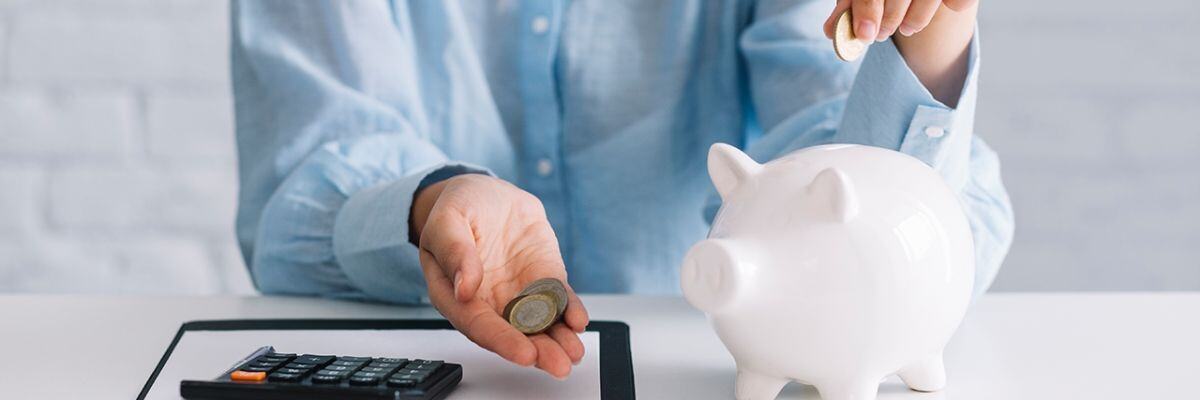 a person putting in coins on a piggy bank