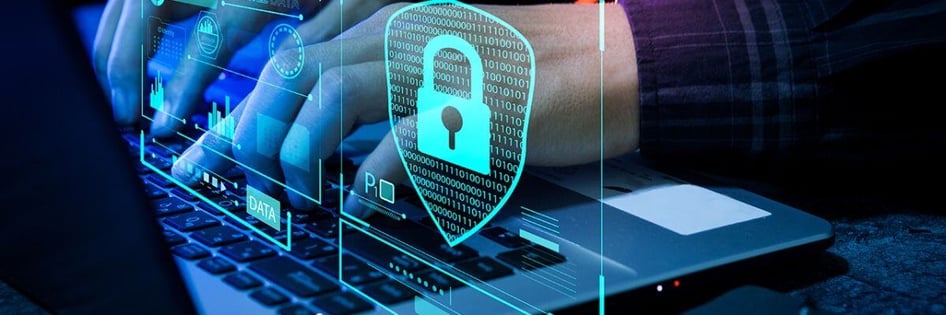 A person typing into his laptop with cybersecurity features