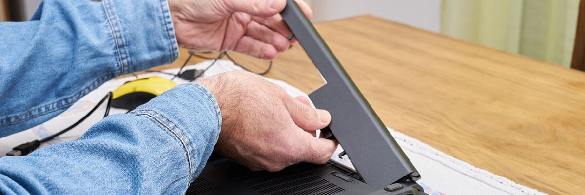 IT technician removing a laptops battery