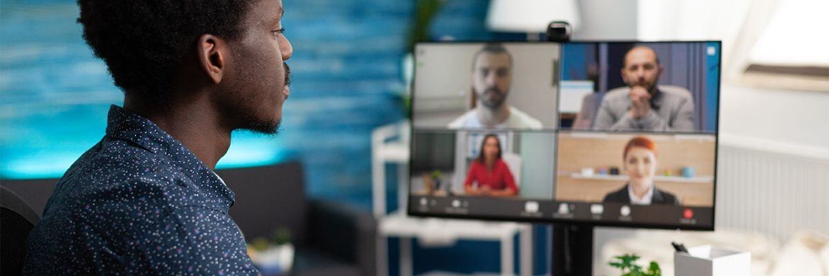 A person with a computer in front of him attending a remote conference