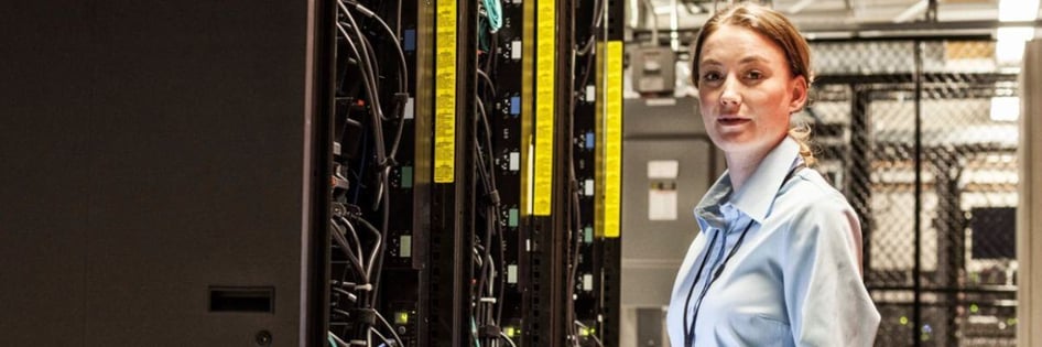An IT Technician standing in front of servers