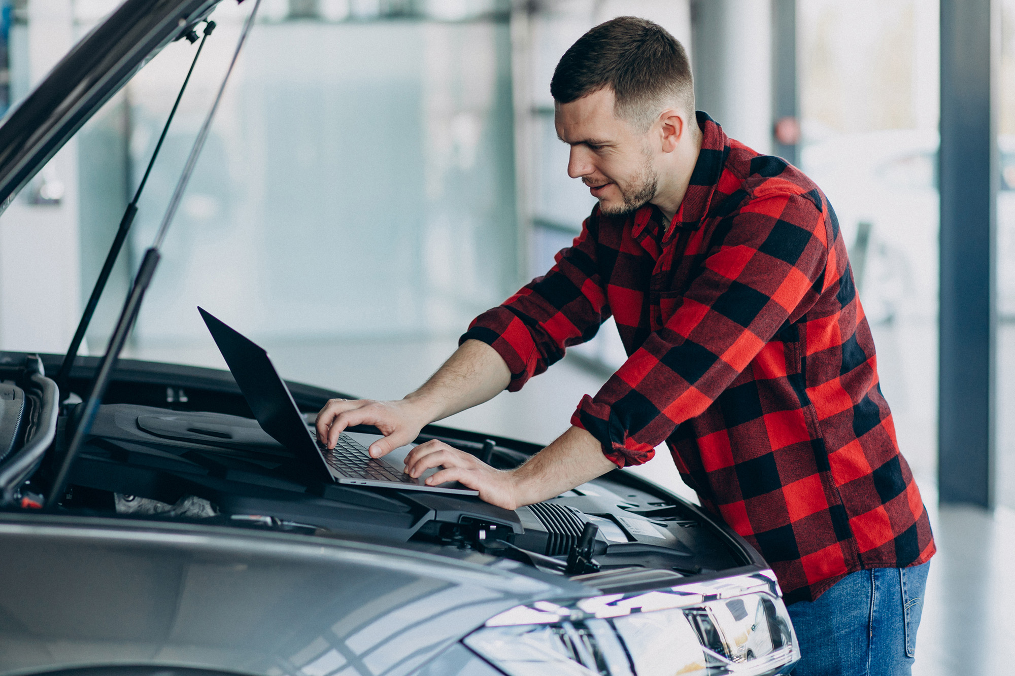 auto_how_step3 (Young man making diagnostics of the vehicle)