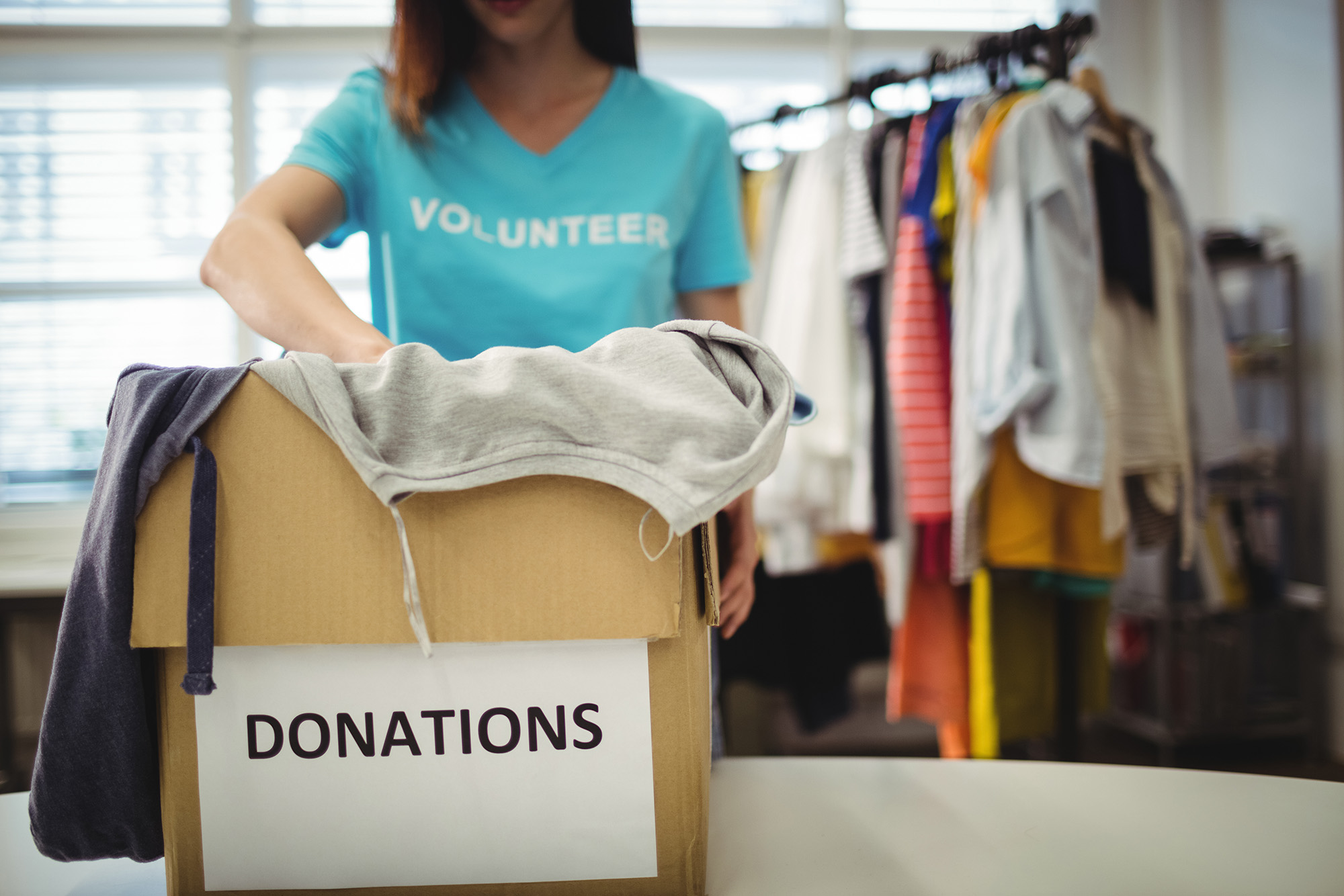 npo_intro (Female volunteer holding clothes in donation box)