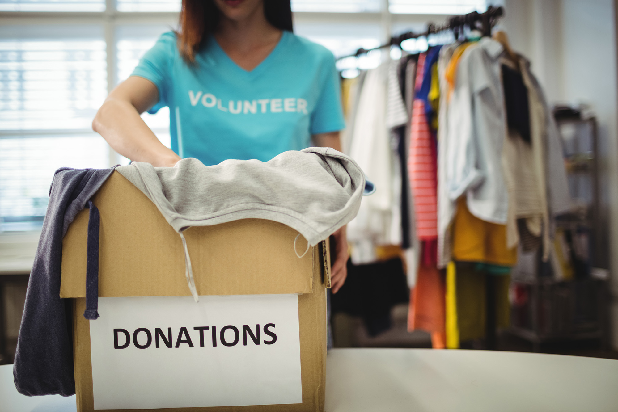 npo_intro (Female volunteer holding clothes in donation box)