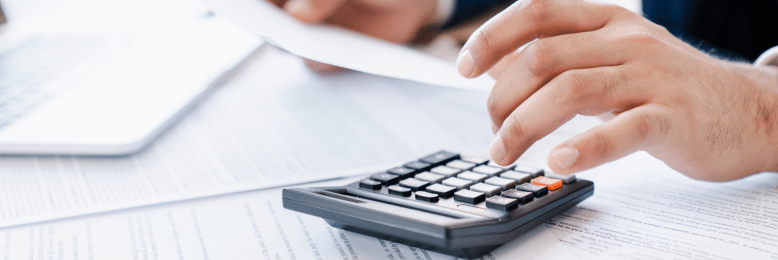 Professional analyzing co-managed IT costs with calculator and documents