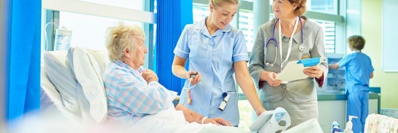 Nurses and physicians supporting a rural hospital patient, highlighting care coordination that helps prevent revenue leakage.