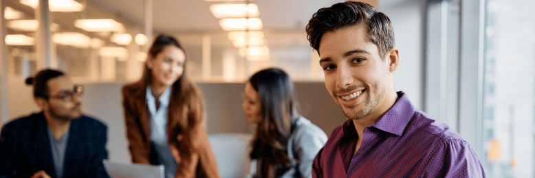 Smiling businessman on laptop reviewing IT plan options in a meeting