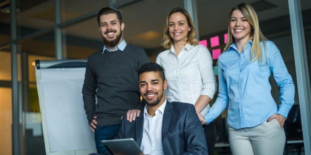 Smiling professionals in an office setting, representing the advantages of meeting new managed service providers.