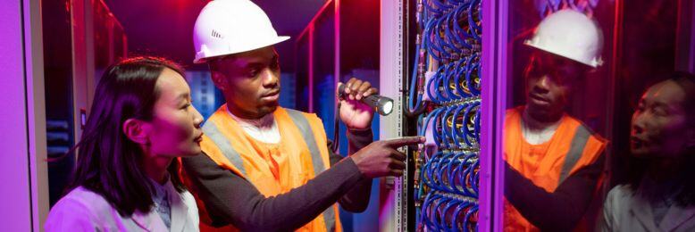 Technicians in a data center managing server infrastructure, highlighting active monitoring