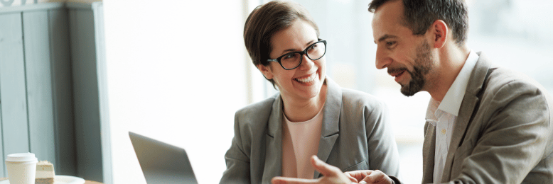 Two professionals in a cafe, engaged in a strategic discussion about CIO versus vCIO roles