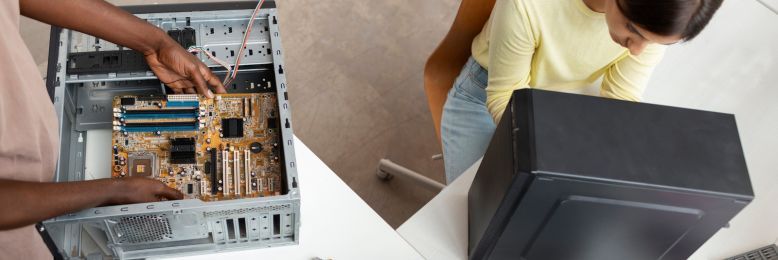 Two technicians collaboratively working on the disposal of outdated computer hardware