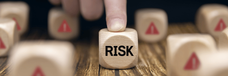 a finger pointing at a cube with the word risk