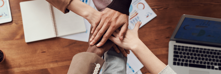 a group of people with their hands on top of each other