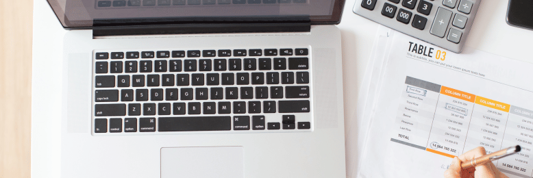 a person making a computation beside a laptop