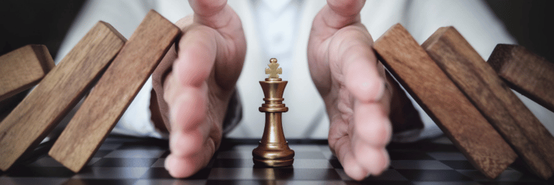 a person protecting the king chess piece from blocks