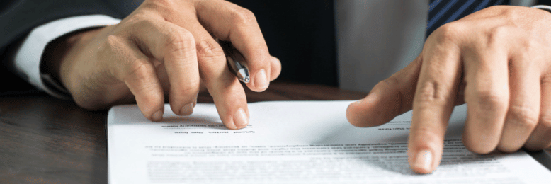 a person reading and signing a contract