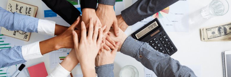 a team of employees putting their hands together
