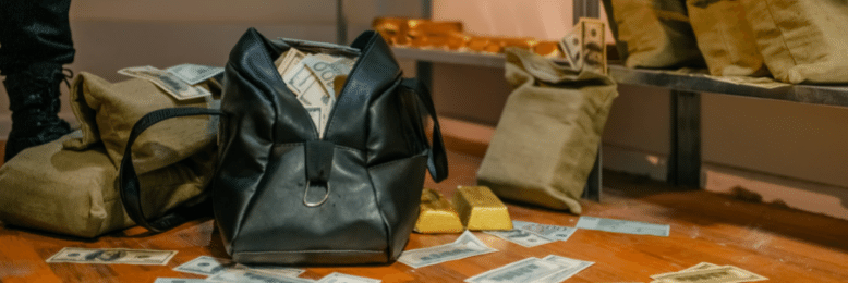 a thief putting in money and gold bars into a black bag
