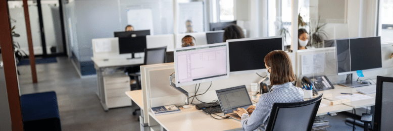 an office setup with barriers between employee stations