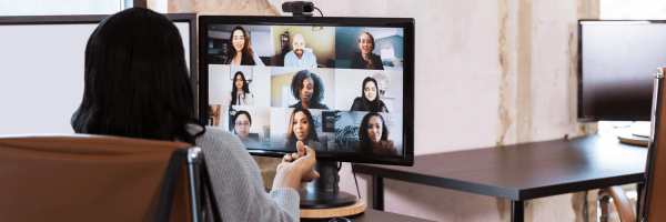 A professional participating in a video conference with colleagues, showcasing an organized workspace and optimal camera positioning for virtual meetings.