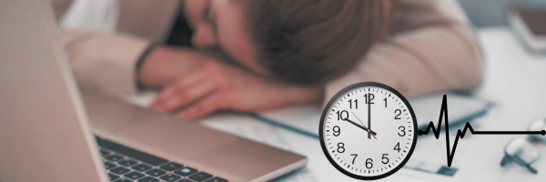 Exhausted employee resting their head on a desk with a laptop, clock, and heart rate line symbolizing the impact of sleep deprivation on health and productivity.