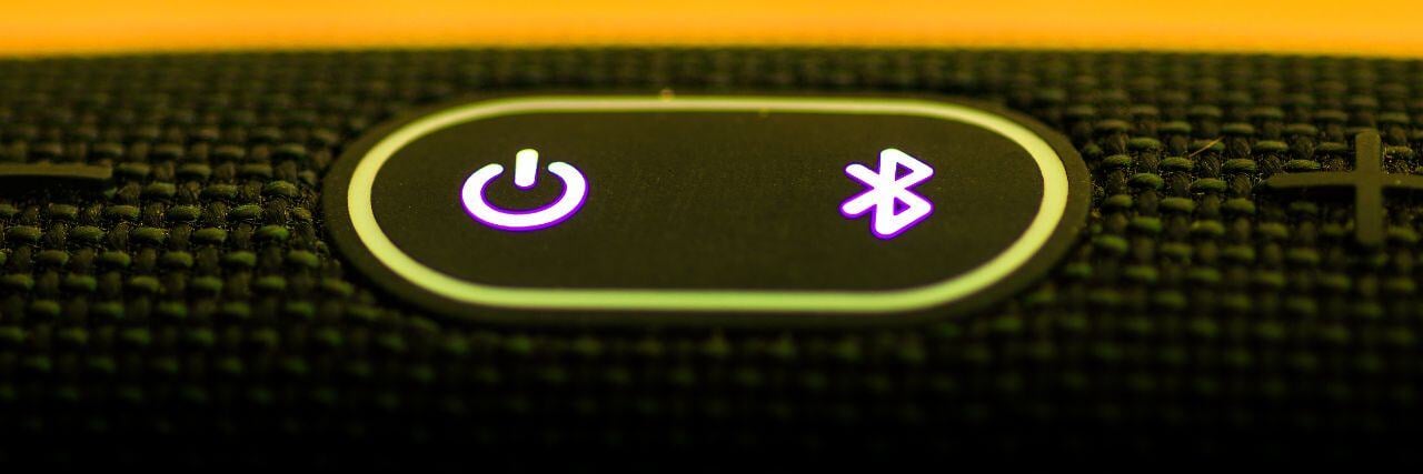 a bluetooth button beside the power button on a portable speaker