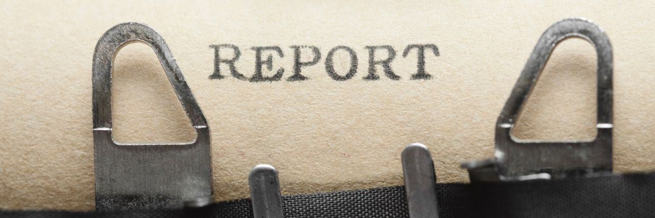 the word report typewritten on a brown paper still in the type writter