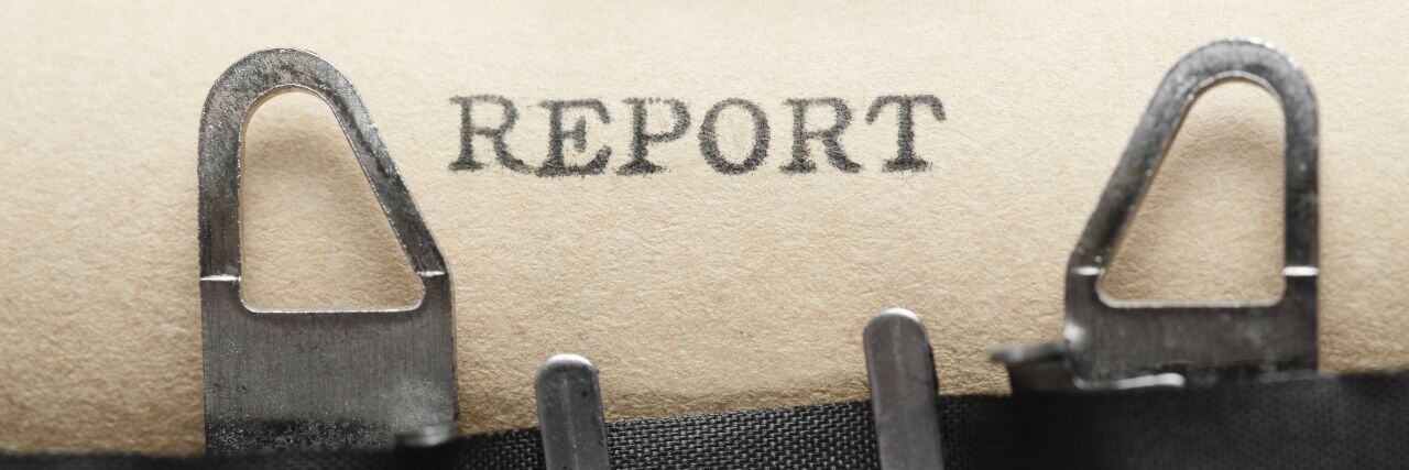 the word report typewritten on a brown paper still in the type writter