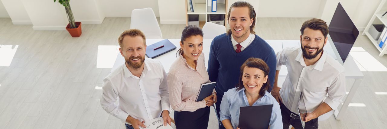 a team of happy employees in office background
