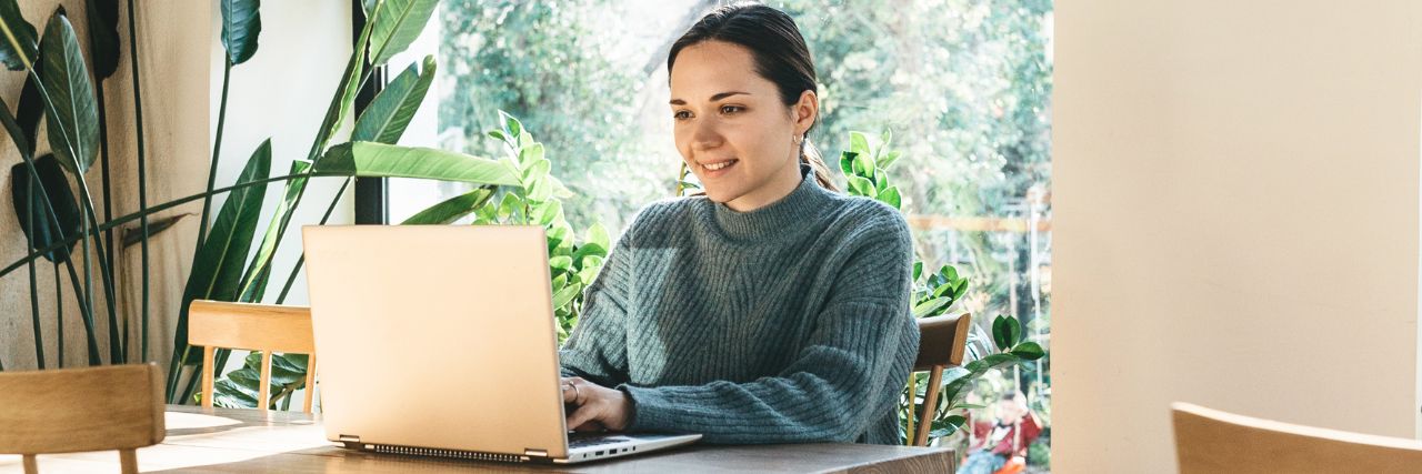 A person on a laptop working remotely using cybersecurity best practices