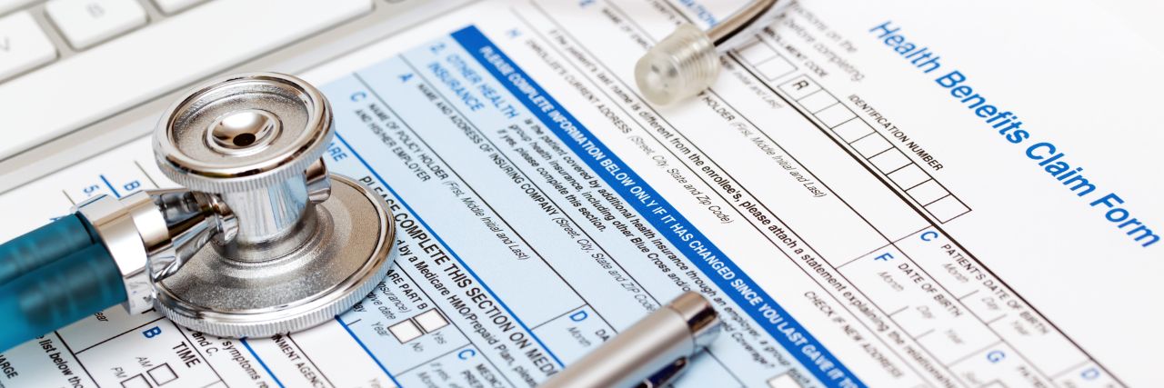 a stethoscope on top of a health benefits form